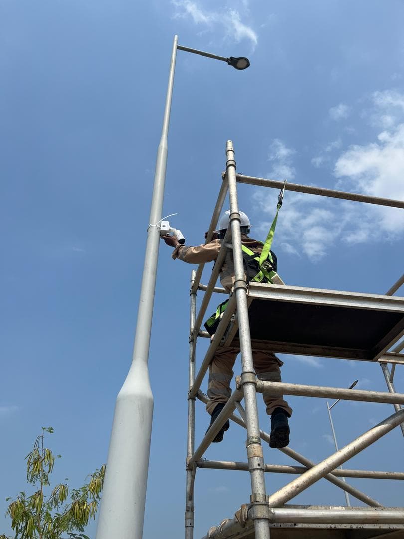 Working at height, harnessed, to fit a bullet camera to a street-lighting column.