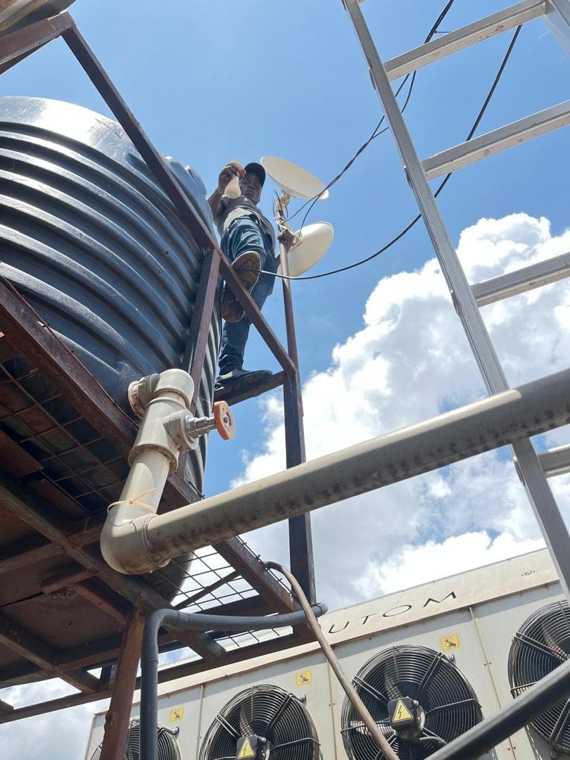 Aligning a pair of dishes on a rooftop gantry to carry a link between two buildings.